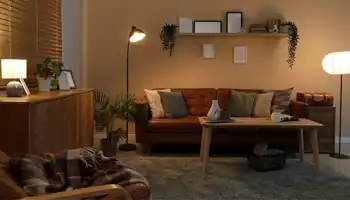 Intérieur d'un salon sombre avec des lampes lumineuses, un canapé et une étagère, la nuit