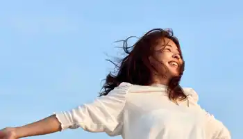 Une femme rayonnante embrassant le ciel